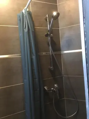 a shower in a bathroom with a shower curtain at Leonard room in Liège