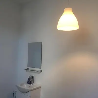 a bathroom with a light on the wall and a toilet at Leonard room in Liège