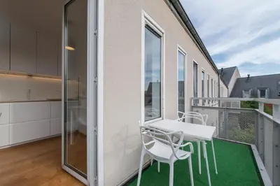 a balcony with a white table and chairs at Studio des jardins suspendus in Liège