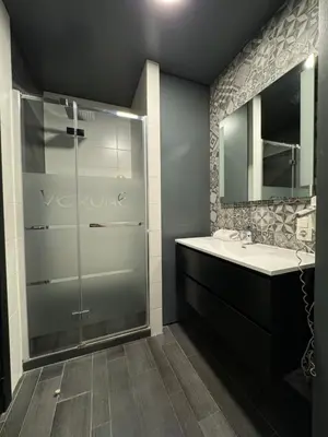 a bathroom with a glass shower and a sink at L'écrin des Vennes - Liège centre in Liège