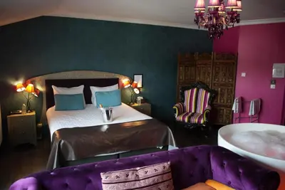 a bedroom with a bed and a tub in a room at L'écrin des Vennes - Liège centre in Liège