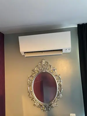 a mirror on a wall with a air compressor at L'écrin des Vennes - Liège centre in Liège