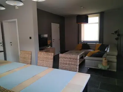 a living room with a couch and a living room with a couch at Vakantiewoning Mierzicht - privé wellness - Haspengouw 6p in Boekhout