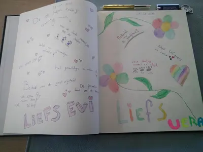 a book with writing and flowers on the pages at Vakantiewoning Mierzicht - privé wellness - Haspengouw 6p in Boekhout