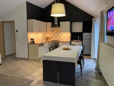 a kitchen with a table with a white counter top at Thier à Liege - hauts-sart in Liège