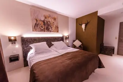 a bedroom with a large bed with a deer head on the wall at ManavaHotel in Herstal