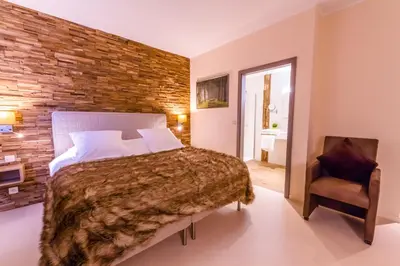 a bedroom with a bed and a brick wall at ManavaHotel in Herstal