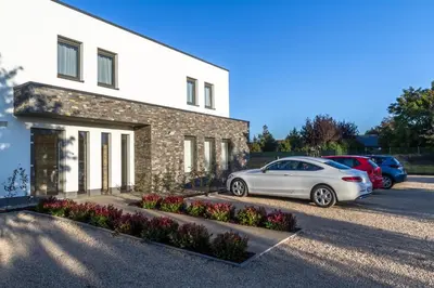 a white car parked in front of a building at ManavaHotel in Herstal