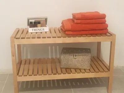 a wooden shelf with towels and a box on it at Wijndomein Zwaeneberg in Voeren