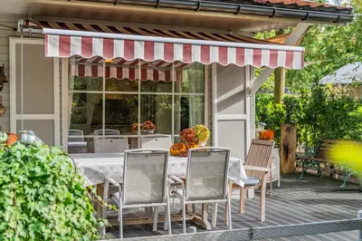 a patio with a table and chairs on a porch at Chalet 2Relax in Zutendaal