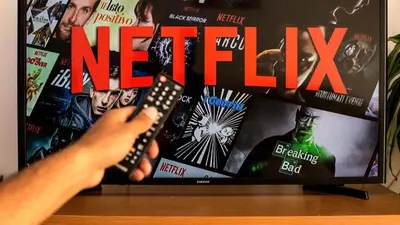 a person holding a remote control in front of a tv at Chalet 2Relax in Zutendaal