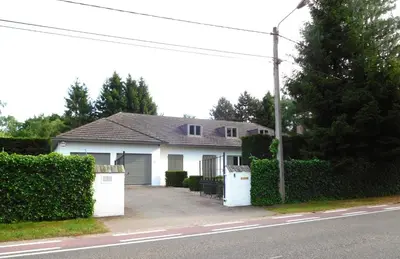 a white house with a fence and a driveway at Suite Horatio in Heusden - Zolder