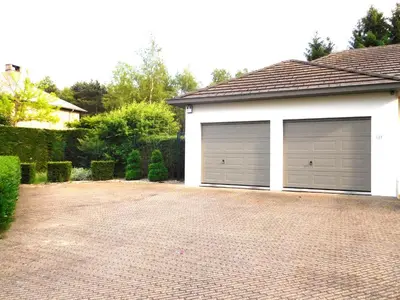 two garage doors on a house with a brick driveway at Suite Horatio in Heusden - Zolder