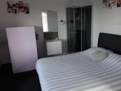 a bedroom with a white bed and a glass shower at Villa Marco 176 in Cerexhe-Heuseux