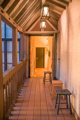 a wooden porch with a light and benches on it at Hotel Neuvice in Liège