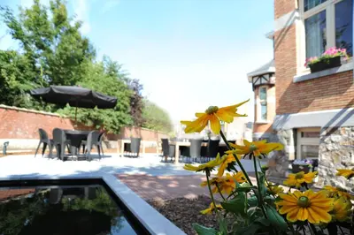 a garden with yellow flowers and a table and chairs at Charmehotel Villa Saporis in Hasselt