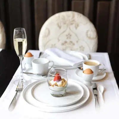 a table with a plate with a dessert and a glass of wine at Charmehotel Villa Saporis in Hasselt