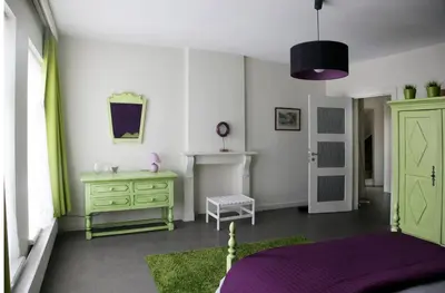 a bedroom with a green dresser and a green door at Aux Herbes Folles in Herve