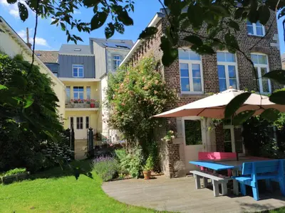 a house with a picnic table and an umbrella at Aux Herbes Folles in Herve