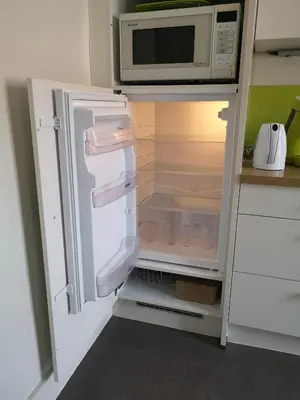 an open refrigerator with a microwave on top of it at Aux Herbes Folles in Herve