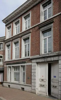 a brick building with white doors and windows at Aux Herbes Folles in Herve