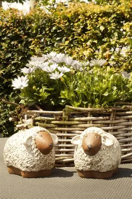two stuffed sheep sitting next to a basket of flowers at Kampenhof in Maaseik