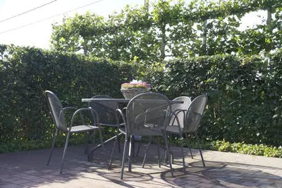 a table with chairs and a basket of flowers at Kampenhof in Maaseik