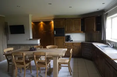a kitchen with a wooden table and wooden chairs at Kampenhof in Maaseik