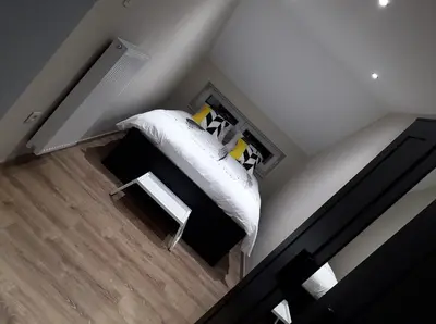 a bedroom with a bed with a white blanket and pillows at Chez Vivi in Ans