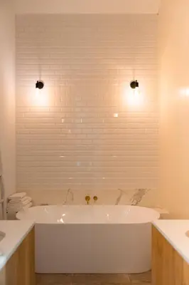 a white bath tub in a bathroom with two lights at Winning De Zwaen in Hasselt