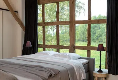 a bed in a room with a large window at Winning De Zwaen in Hasselt