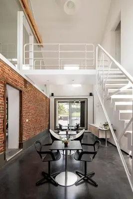 a dining room with a table and chairs and a staircase at B&B Bed and Beyond in Oudsbergen