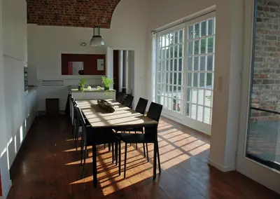 a dining room with a table and black chairs at De Waterkriek in Borgloon