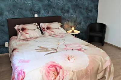 a bedroom with a bed with pink flowers on it at Juwel Fruithof in Zepperen