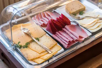 a display case with cheese and meats and cheeses at De Pastorie in Borgloon