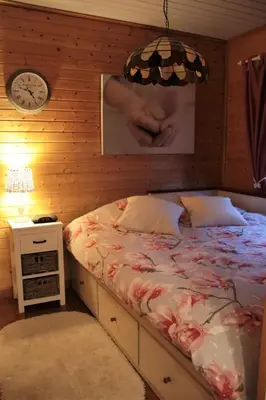 a bedroom with a bed and a clock on the wall at Charme chalet in Zutendaal