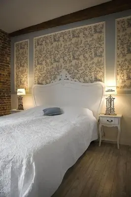 a bedroom with a large white bed and a brick wall at Auberge 's Gravenhof in Voeren