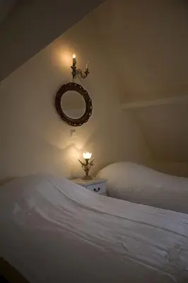 a bedroom with two beds and a mirror on the wall at Auberge 's Gravenhof in Voeren
