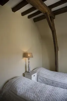 a bedroom with two beds and a lamp on a night stand at Auberge 's Gravenhof in Voeren