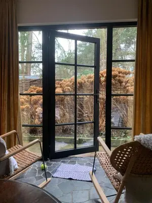 a room with two chairs and a large window at Vakantiehuis ABEL in Dilsen-Stokkem
