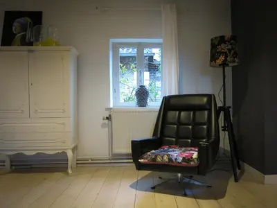 a black chair in a room with a window at SintPieter17 Lo-Ghis vakantiewoning in Voeren