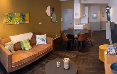 a living room with a couch and a table at Domus Basil in Tongeren