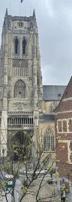 a large stone building with a clock tower at Domus Basil in Tongeren