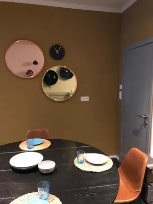 a black table with chairs and plates and a mirror at Domus Basil in Tongeren