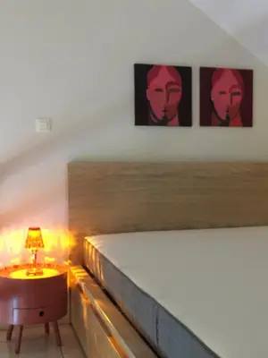 a bedroom with a bed and a table with a lamp at Domus Basil in Tongeren