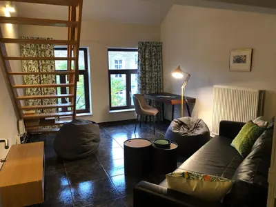 a living room with a couch and a table at Domus Basil in Tongeren