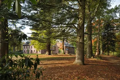 a large house in the middle of a park with trees at Het Domherenhuis B&B, Restaurant Calice in Heusden - Zolder