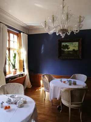 a dining room with two tables and a chandelier at Het Domherenhuis B&B, Restaurant Calice in Heusden - Zolder
