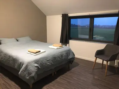 a bedroom with a bed and a chair and a window at Joff in Budingen