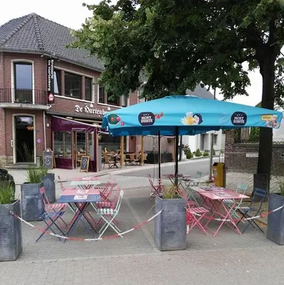 a table and chairs under a blue umbrella on a street at Vakantiewoning Bij de Jep in Bilzen